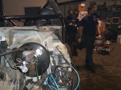 1995 Ford Bronco - The vehicle's engine bay is disassembled, revealing the brake booster and extensive wiring.