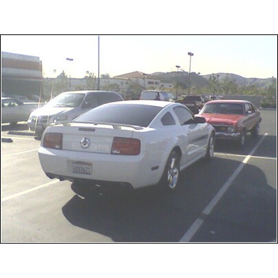 1972 Ford Ranchero - A white coupe is parked in a lot next to other vehicles.