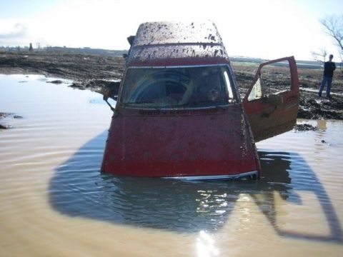 1986 Ford Bronco - This 1986 Ford Bronco is stuck deep in mud and water, with the driver's door ajar.