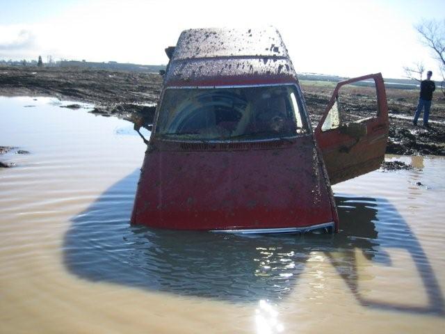 1986 Ford Bronco stuck in mud with driver's door open