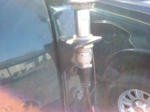 1995 Ford Bronco - Detail of an antenna mount on the side of a dark green vehicle, unidentified vehicle.