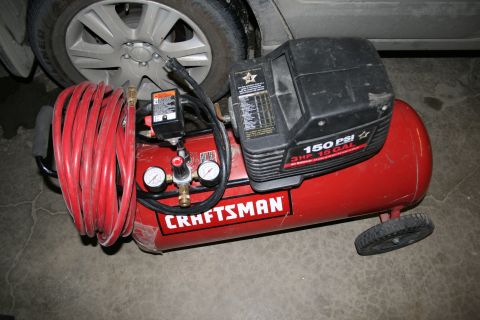 2003 Jeep TJ - A red Craftsman air compressor with a 15-gallon tank and 3 HP motor is shown with a coiled red hose and two pressure gauges.