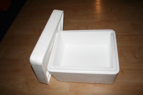 2003 Jeep TJ - An empty styrofoam cooler with its lid ajar sits on a wooden floor.