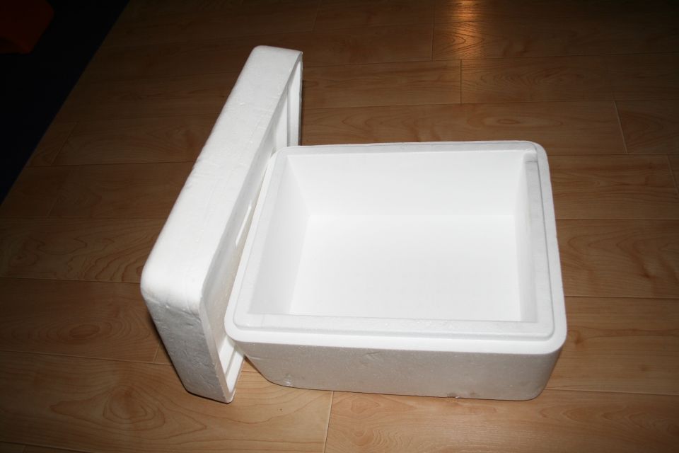 Open styrofoam cooler on a wood floor