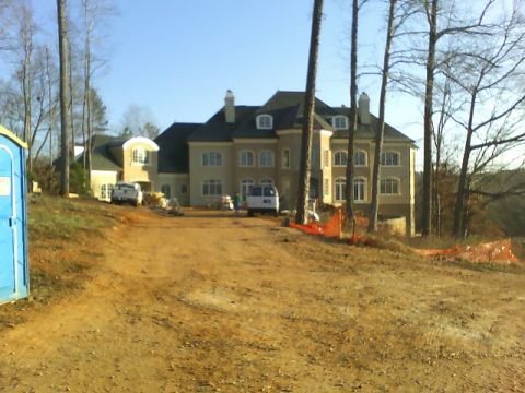1979 Ford Ranchero - A large house is under construction, with vehicles and a portable toilet on site.