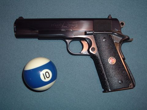 1995 Mercury Grand Marquis - A Colt 1911 pistol is shown next to a billiard ball marked with the number 10.
