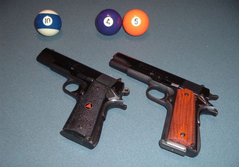 1995 Mercury Grand Marquis - Two handguns and three pool balls are arranged on a blue surface, possibly a pool table.