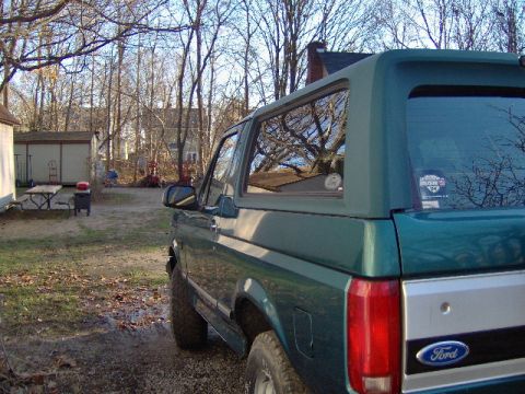 1996 Ford Bronco - A green Ford Bronco is parked in a yard during autumn.