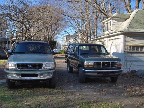 1996 Ford Bronco - Two Ford SUVs, a 1997 Expedition and a Bronco, are parked in a residential driveway.