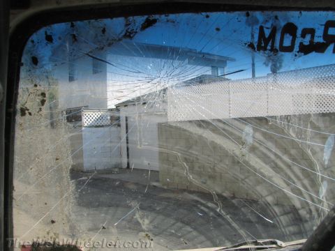 1987 Suzuki Samurai - The windshield is heavily cracked, obscuring the view of the buildings and fence outside.
