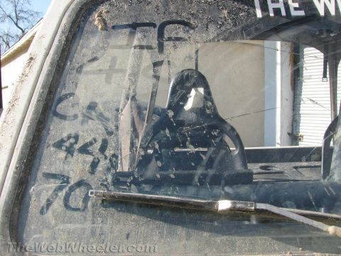 1987 Suzuki Samurai - Graffiti on the rear window of a vehicle, with a headrest visible inside.