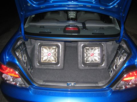 2007 Subaru Impreza - The trunk of a blue Subaru Impreza contains a custom audio system with two large subwoofers.