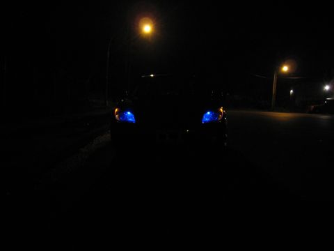 2007 Subaru Impreza - A car with striking blue headlights is seen from the front at night, illuminated by streetlights.