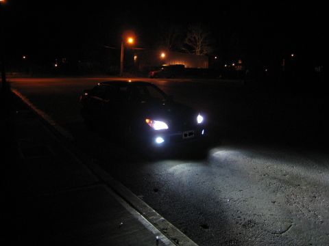 2007 Subaru Impreza - Car's headlights are on at night, casting light onto the street.