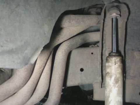1992 Ford F-350 - Vehicle undercarriage showing exhaust manifold pipes and a shock absorber.