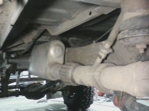 1992 Ford F-350 - Close-up view of the exhaust system and rear suspension of a truck, showing the muffler and axle.