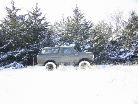 1978 Ford Bronco - A 1978 Ford Bronco sits in a snowy field surrounded by snow-dusted trees.