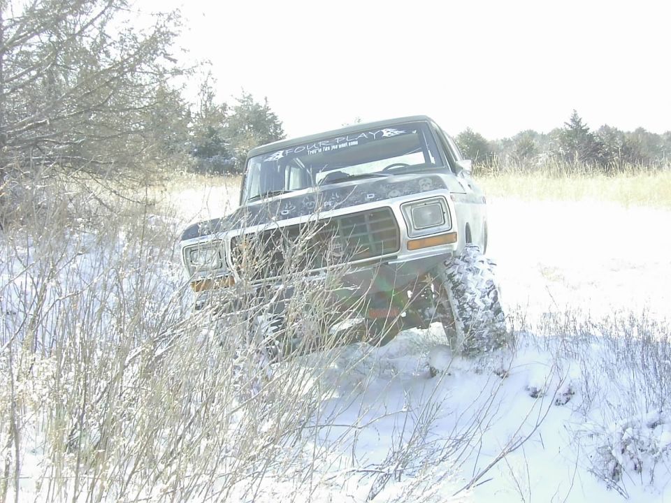 1978 Ford Bronco front view in snow with "FOUR PLAY" sticker on windshield