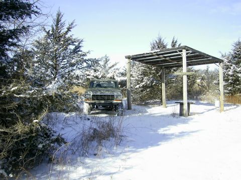 1978 Ford Bronco - A truck sits in a snowy landscape next to a picnic shelter.