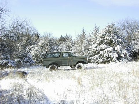 1978 Ford Bronco - A 1978 Ford Bronco sits in a snow-covered field surrounded by winter trees.