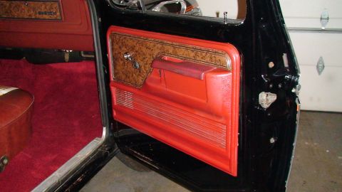 1979 Ford F-150 - The interior of a 1979 Ford F-150 shows a red door panel with wood grain accents and plush red carpeting.