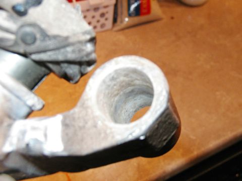 1993 Ford Bronco - This metal linkage part has a hole in the center and a Supermotors logo in the corner.