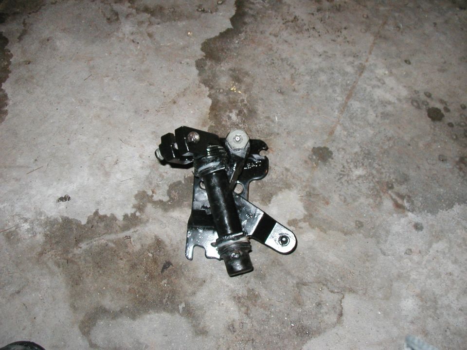 Black shifter linkage part on concrete floor