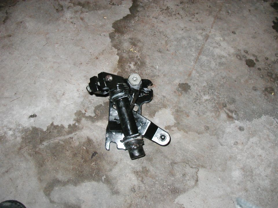 Black metal shifter linkage assembly on concrete floor