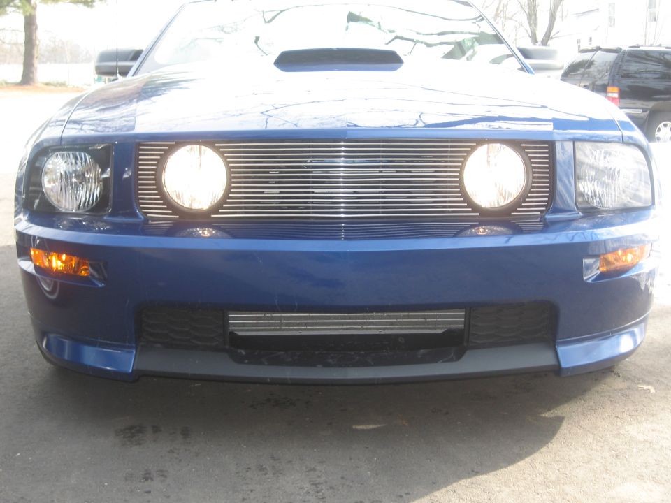 Blue 2007 Ford Mustang front grille with two round fog lights and horizontal bars, headlights visible