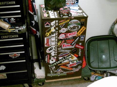 1986 Ford Bronco - A toy truck sits atop a cabinet adorned with numerous automotive-themed stickers.