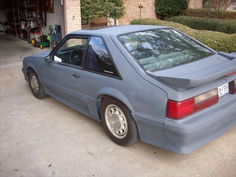 1989 Ford Mustang - This 1989 Ford Mustang coupe is seen from a 3/4 front angle, showing its spoiler and primer finish.