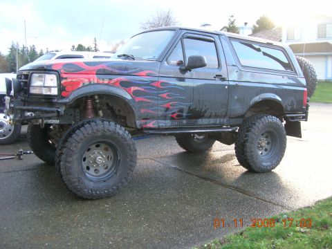 1996 Ford Bronco - This modified Ford Bronco features custom flame graphics and off-road tires.