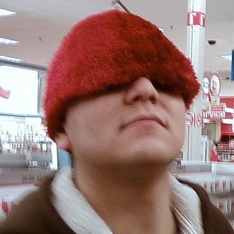 2007 Mazda 3 - A person is seen wearing a bright red, fuzzy hat that covers their eyes.