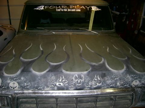 1978 Ford Bronco - The hood of a truck features custom airbrushed flames and skulls, with a banner on the windshield.