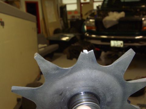 1996 Ford Bronco - A close-up of a damaged gear is shown, with a dark green truck visible in the blurred background.