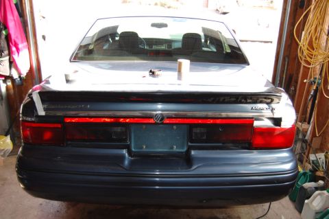 1985 Mercury Grand Marquis - Rear view of a Mercury sedan with a spoiler, possibly a Grand Marquis, parked in a garage.