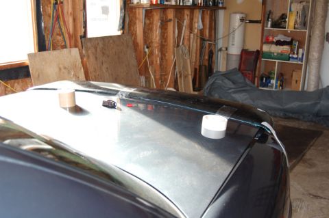1985 Mercury Grand Marquis - A rear spoiler is attached to the trunk of a car with tape and other fasteners.