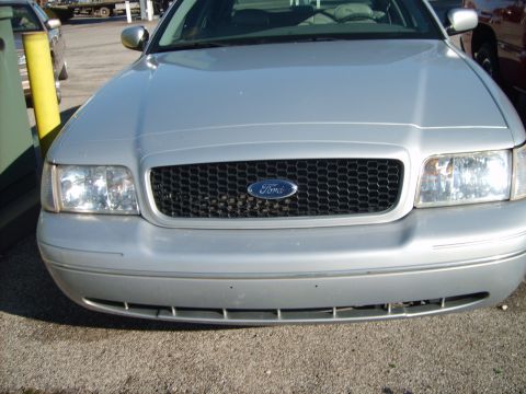 1993 Ford Crown Victoria - Head-on view of the front end of a silver Ford Crown Victoria, showing the black honeycomb grille with blue Ford oval, clear-lens headlight…