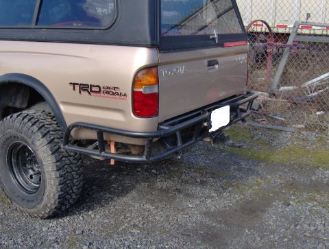 1978 Ford Bronco - The rear of a Toyota pickup truck is shown, a TRD Off-Road decal and a heavy-duty aftermarket bumper.