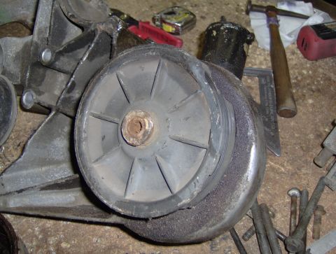 1978 Ford Bronco - A close-up view of a vehicle's water pump pulley and bracket, with various tools visible in the background.