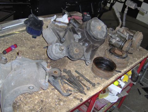 1978 Ford Bronco - Various engine components are laid out on a workbench, suggesting a repair or rebuild process.