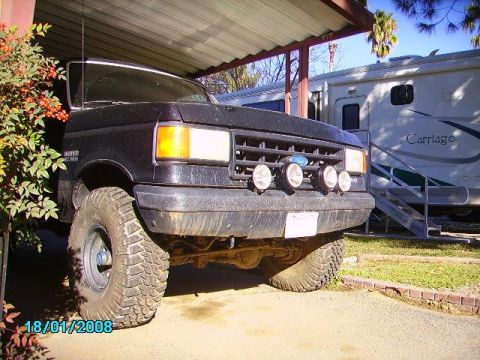 1990 Ford Bronco - Front view of a black 1990 Ford Bronco with large off-road tires, parked outdoors.