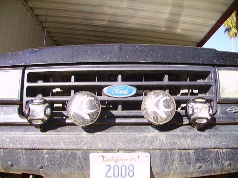 1990 Ford Bronco - Front view of a 1990 Ford Bronco's grille, equipped with auxiliary lights and a California license plate.