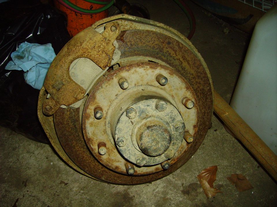 rusted brake drum and caliper assembly, looks like it's from a truck or heavy equipment