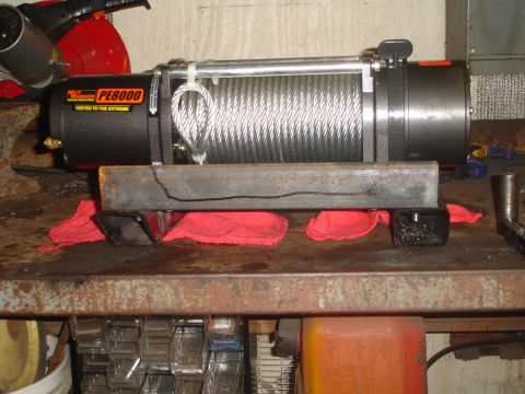 1989 Ford Bronco - A winch is mounted on a metal bar, supported by red cloths.