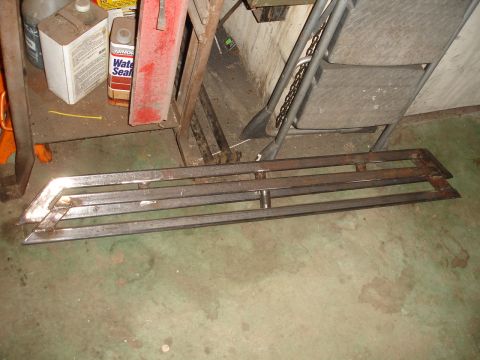 1989 Ford Bronco - Unidentified metal parts, possibly aftermarket vehicle accessories, are stored indoors.