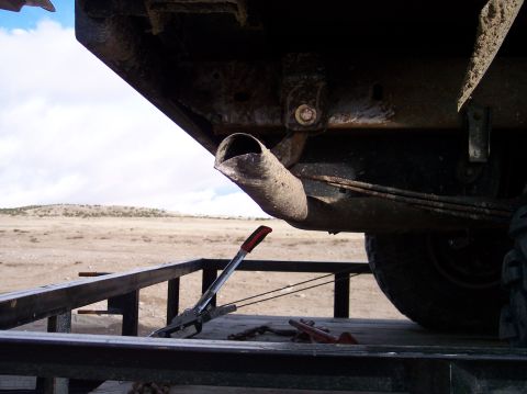1995 Ford Bronco - The underside of a vehicle, including its exhaust pipe and trailer hitch, is visible while on a trailer.
