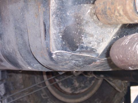 1995 Ford Bronco - Close-up view of a vehicle's undercarriage, revealing mechanical components and a tire.