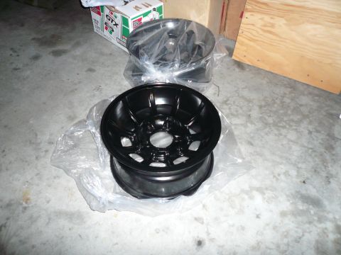 1975 Ford Ranchero - Two new black alloy wheels are shown on a concrete floor, possibly for sale or storage.