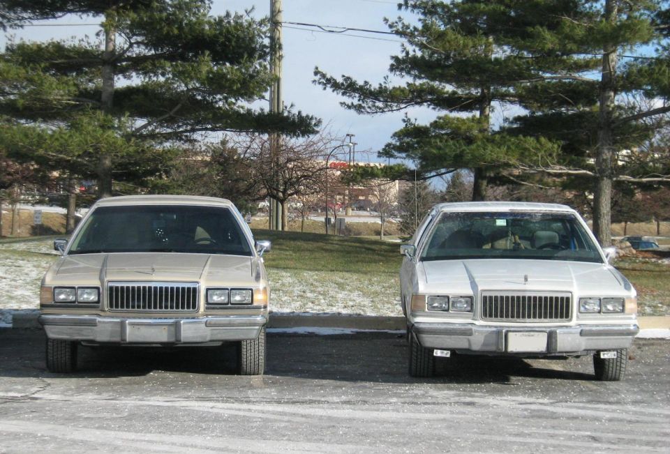 Two 1988 Mercury Grand Marquis sedans parked side-by-side, front view